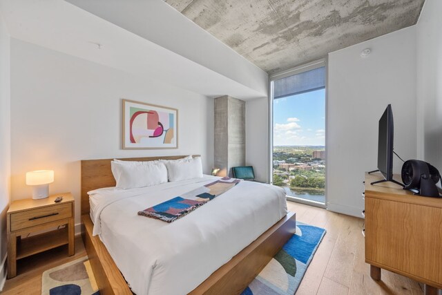 bedroom with light hardwood / wood-style flooring and expansive windows