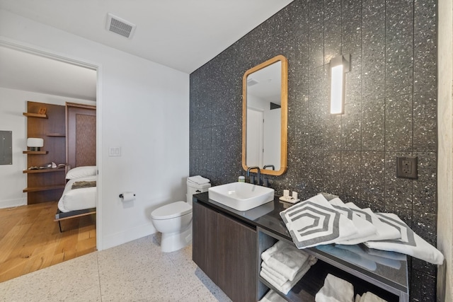 48 E Ave Unit 2511, Austin, TX 78701 - bathroom featuring vanity, toilet, baseboards, electric panel, and connected bathroom
