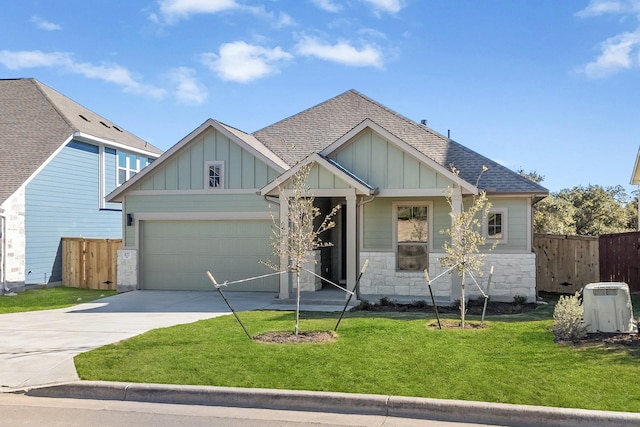 craftsman inspired home with a garage and a front lawn