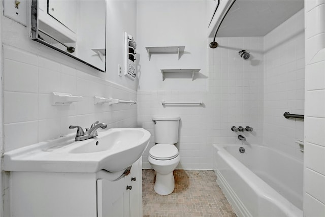 full bathroom with tile walls, vanity, toilet, and tiled shower / bath