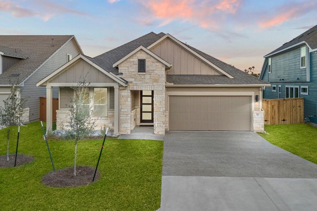 craftsman-style home with a garage and a yard