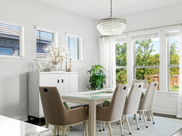 dining area with a chandelier, wood-type flooring, and a wealth of natural light