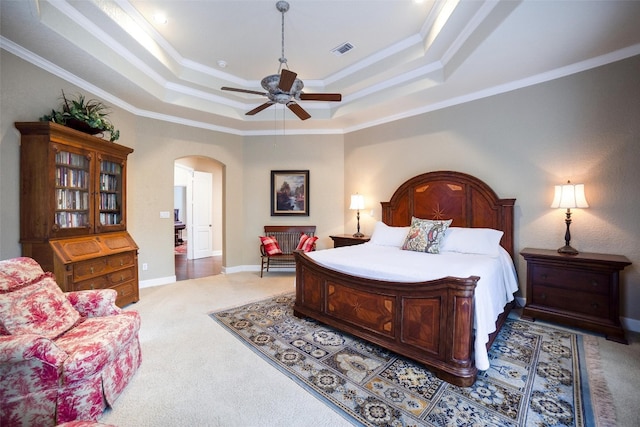 carpeted bedroom featuring ceiling fan, a raised ceiling, and ornamental molding