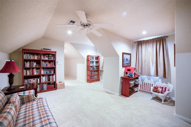 rec room featuring ceiling fan, light colored carpet, a textured ceiling, and lofted ceiling