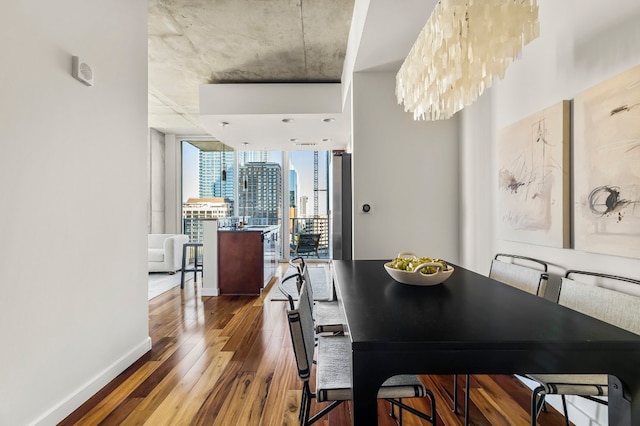 dining area featuring expansive windows, an inviting chandelier, and hardwood / wood-style flooring