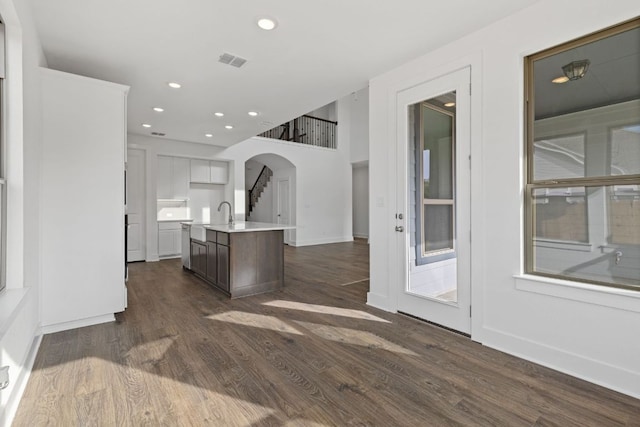 kitchen with recessed lighting, visible vents, light countertops, dark wood finished floors, and a center island with sink