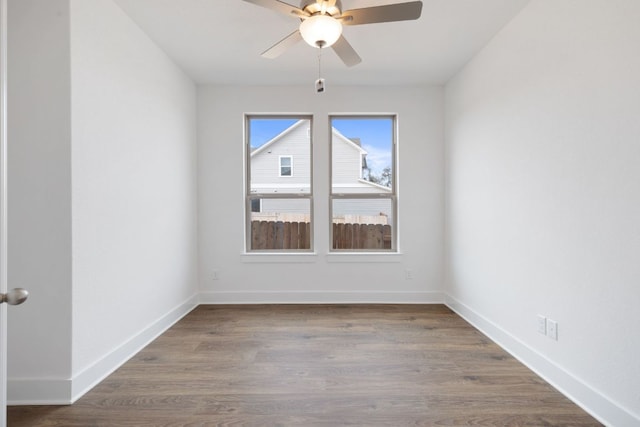 empty room featuring a ceiling fan, baseboards, and wood finished floors