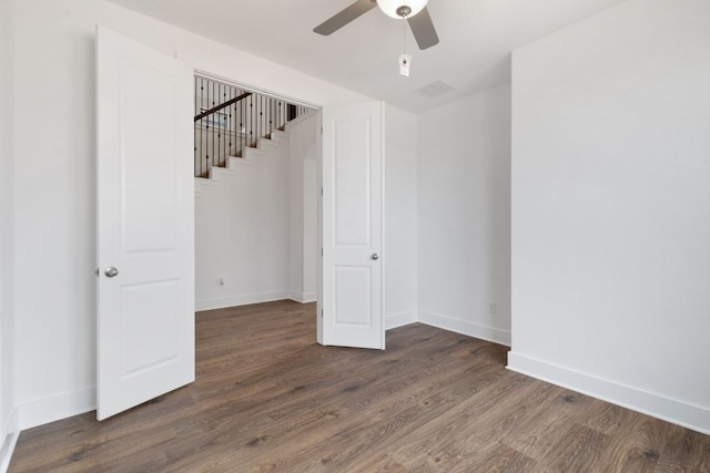 spare room featuring a ceiling fan, visible vents, baseboards, and wood finished floors