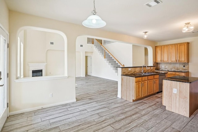 17006 Brewer Blackbird Dr, Pflugerville, TX 78660 - kitchen featuring arched walkways, light wood finished floors, dishwasher, and backsplash