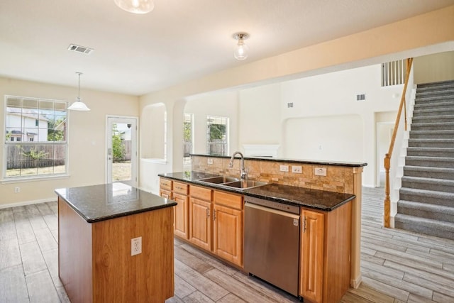 17006 Brewer Blackbird Dr, Pflugerville, TX 78660 - kitchen featuring dishwasher, an island with sink, dark stone countertops, and wood finish floors