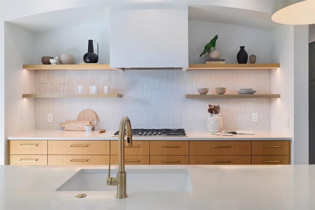 kitchen with sink, stainless steel gas cooktop, and decorative backsplash