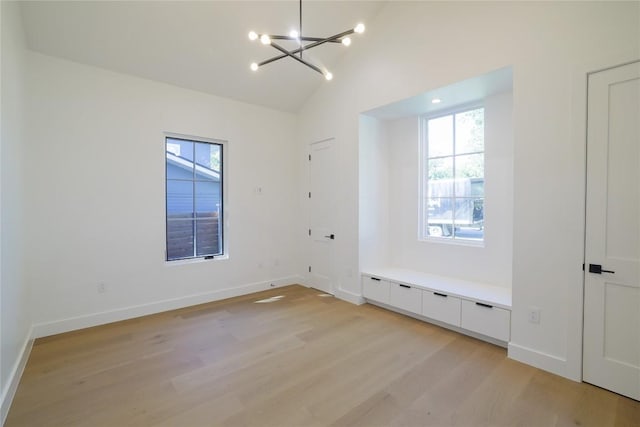 interior space featuring a notable chandelier, light hardwood / wood-style flooring, and vaulted ceiling