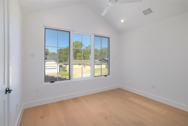 spare room with ceiling fan, lofted ceiling, and light hardwood / wood-style floors