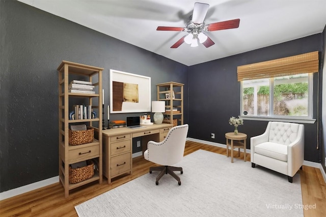 home office featuring light hardwood / wood-style floors and ceiling fan