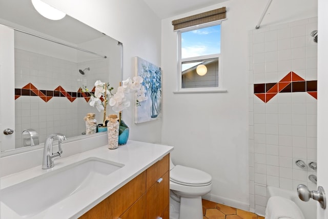 full bathroom with tile patterned flooring, vanity, tiled shower / bath combo, and toilet