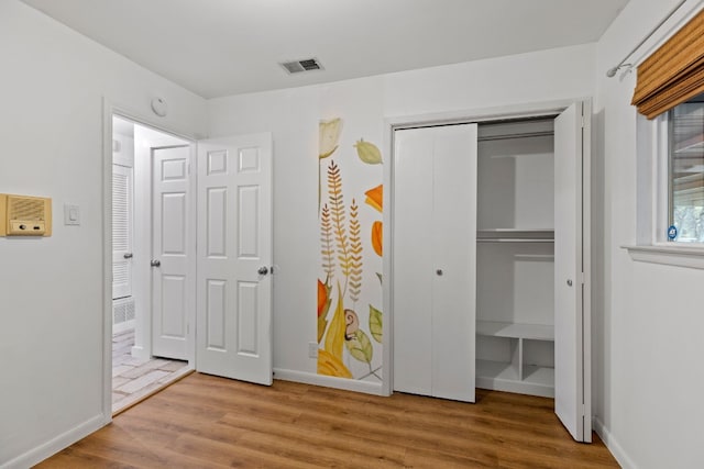 unfurnished bedroom featuring light wood-type flooring and a closet