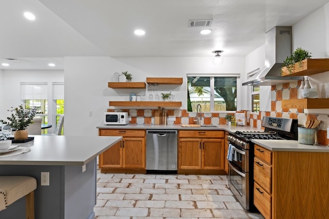 kitchen with tasteful backsplash, sink, extractor fan, and appliances with stainless steel finishes