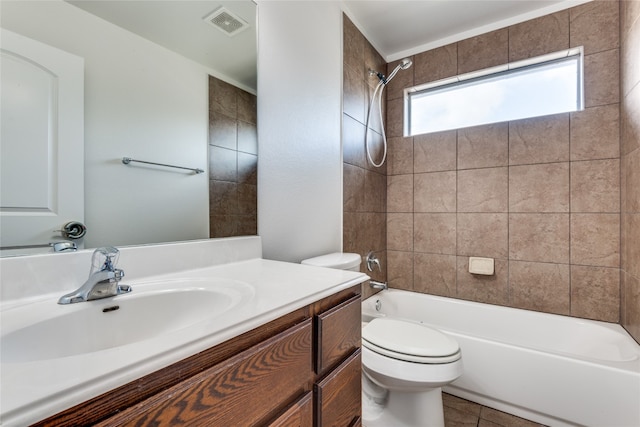 full bathroom with tiled shower / bath, tile patterned floors, vanity, and toilet