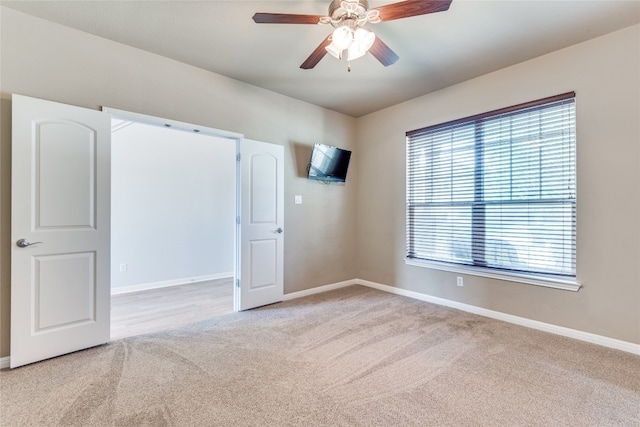 empty room with ceiling fan and light colored carpet