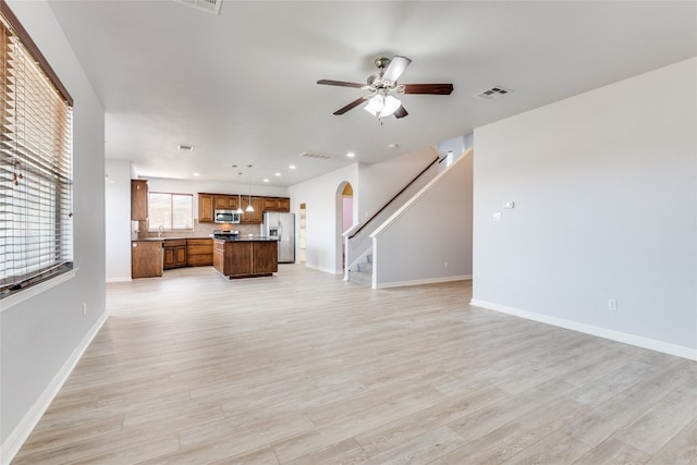 unfurnished living room with ceiling fan and light wood-type flooring