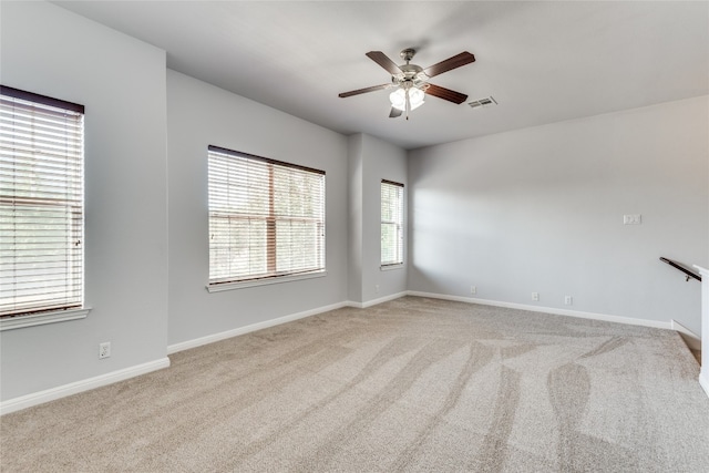 carpeted spare room featuring ceiling fan