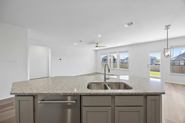 kitchen featuring dark hardwood / wood-style flooring, sink, a healthy amount of sunlight, and a center island with sink