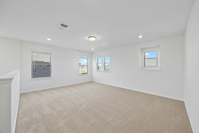 empty room featuring light colored carpet and a wealth of natural light