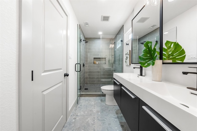 bathroom with a shower with door, vanity, and toilet