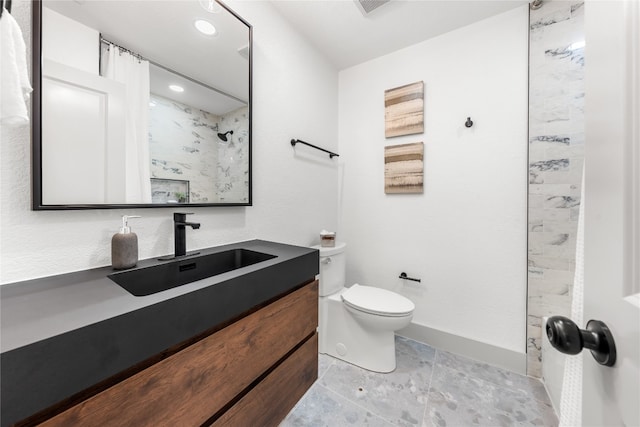 bathroom with vanity, a shower, and toilet