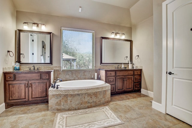 bathroom with tiled tub and vanity