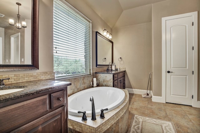 bathroom with tiled tub, vanity, and vaulted ceiling