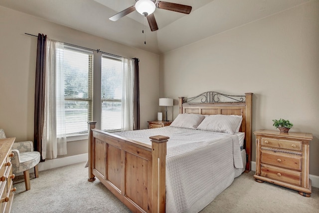 bedroom featuring ceiling fan, light colored carpet, and multiple windows