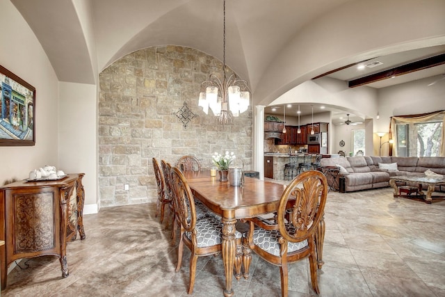 dining room with ceiling fan with notable chandelier and vaulted ceiling