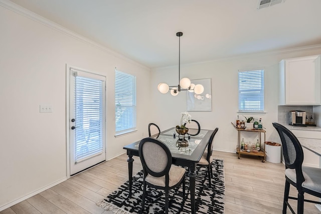 dining area featuring a chandelier, a wealth of natural light, light hardwood / wood-style flooring, and crown molding