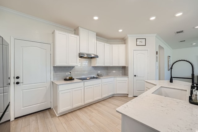 kitchen with sink, white cabinetry, black electric stovetop, and light hardwood / wood-style flooring