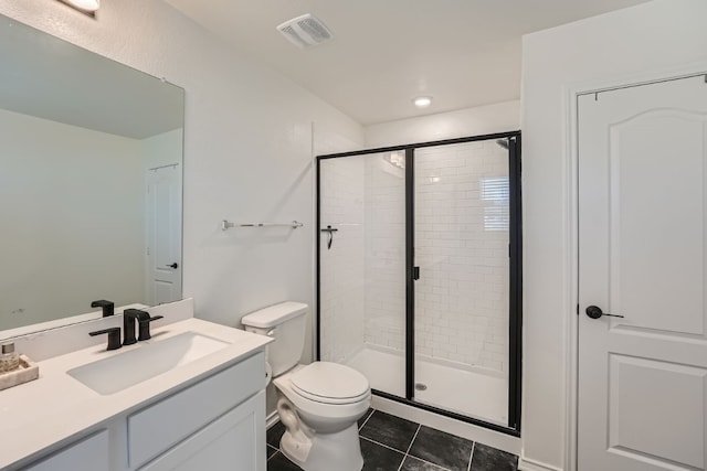 bathroom with a shower with shower door, toilet, vanity, and tile patterned flooring