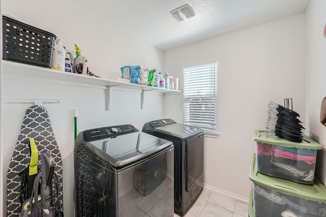 laundry area with light tile patterned floors and washer and clothes dryer