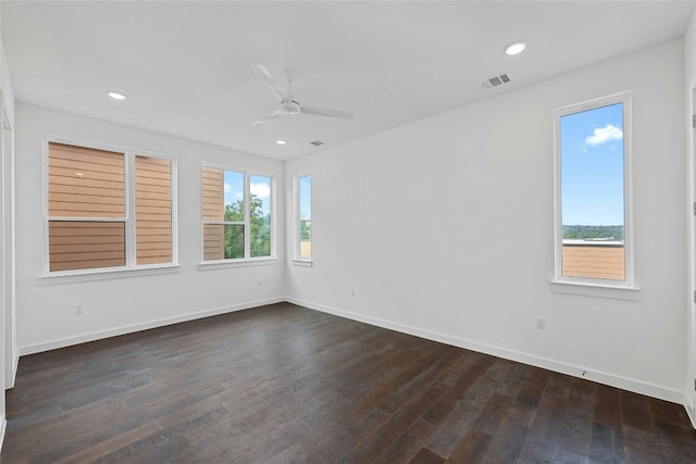 unfurnished room featuring a healthy amount of sunlight, dark wood-type flooring, and ceiling fan