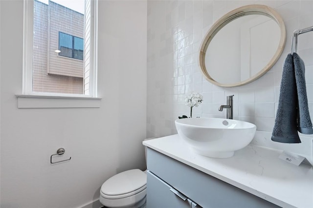 6821 Wolfcreek Pass Unit 12, Austin, TX 78749 - bathroom featuring vanity, toilet, tile walls, and tasteful backsplash