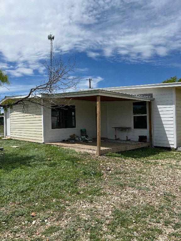 rear view of property featuring a lawn and a patio