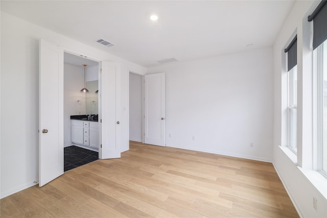 unfurnished bedroom featuring light wood-type flooring and sink