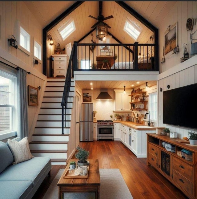 living room featuring hardwood / wood-style floors, a skylight, and a healthy amount of sunlight