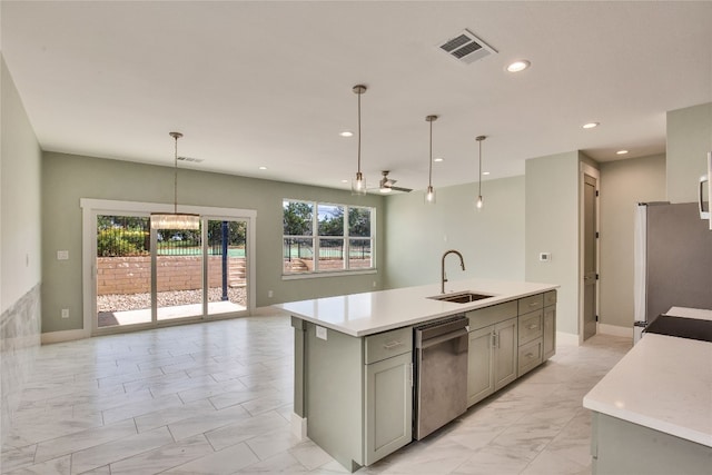 kitchen featuring hanging light fixtures, sink, a center island with sink, gray cabinets, and stainless steel appliances