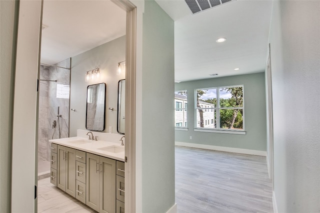 bathroom featuring vanity, hardwood / wood-style flooring, and tiled shower