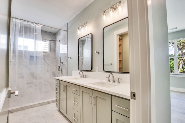 bathroom with vanity and tiled shower