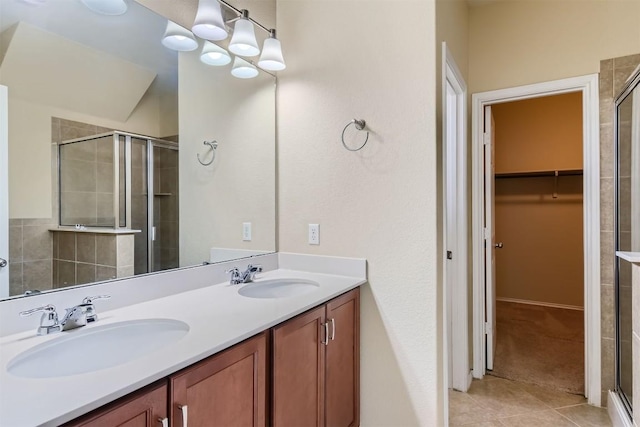 bathroom featuring a sink, tile patterned flooring, a spacious closet, and a shower stall