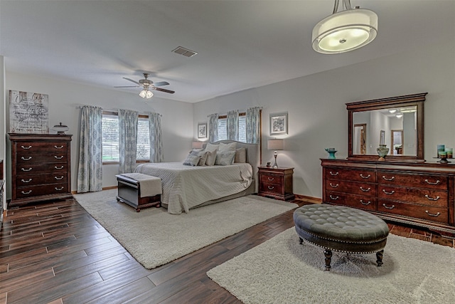 bedroom featuring multiple windows, dark hardwood / wood-style floors, and ceiling fan