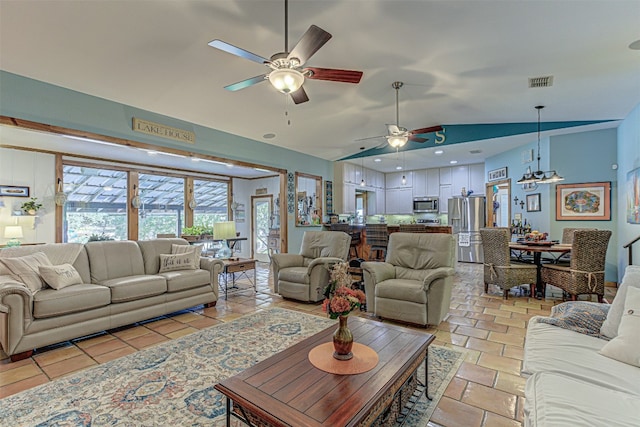 tiled living room featuring ceiling fan with notable chandelier and vaulted ceiling