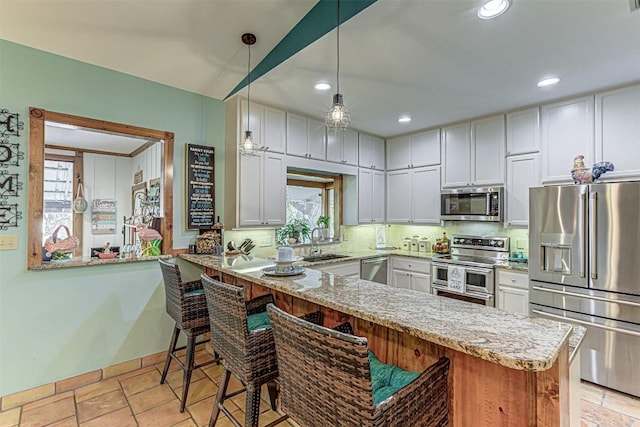1104 Hill Circle W Dr, Granite Shoals, TX 78654 - kitchen with stainless steel appliances, tasteful backsplash, a peninsula, healthy amount of natural light, and recessed lighting
