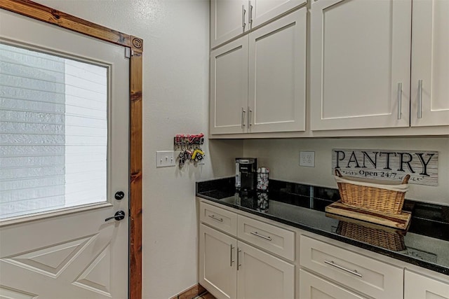 1104 Hill Circle W Dr, Granite Shoals, TX 78654 - kitchen featuring dark stone countertops and white cabinetry